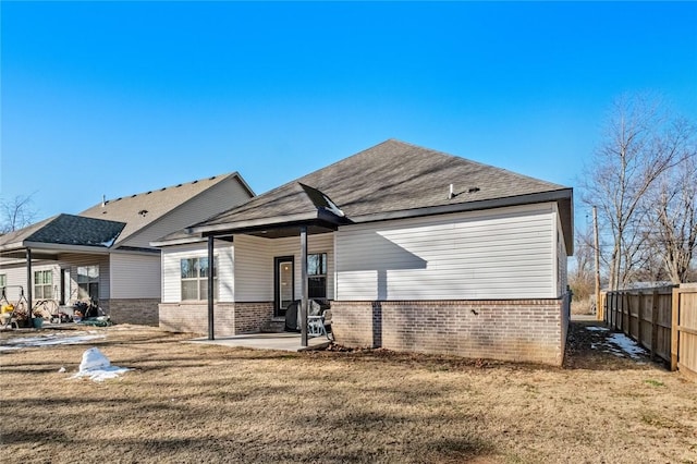 rear view of house featuring a yard and a patio