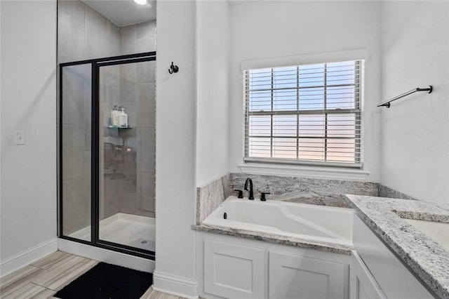 bathroom with a healthy amount of sunlight, vanity, and independent shower and bath