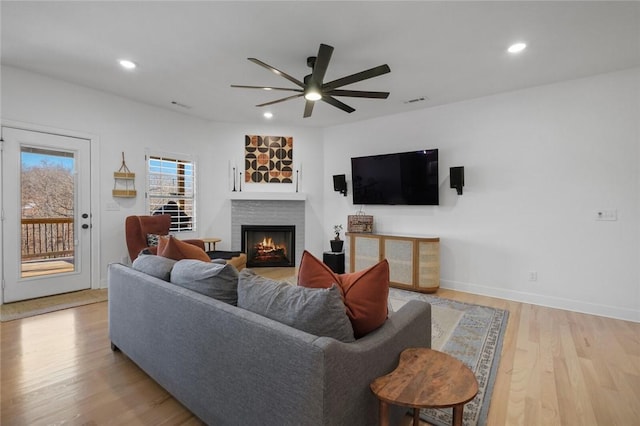 living room featuring ceiling fan and light wood-type flooring