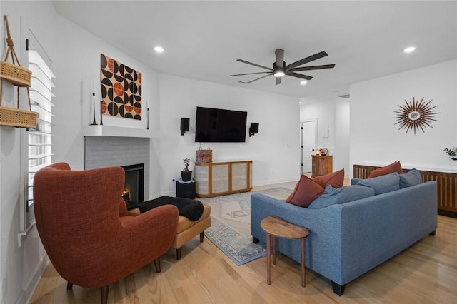 living room with ceiling fan, plenty of natural light, and light hardwood / wood-style flooring