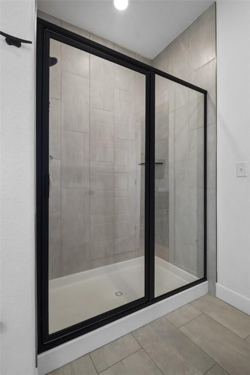 bathroom with an enclosed shower and tile patterned flooring