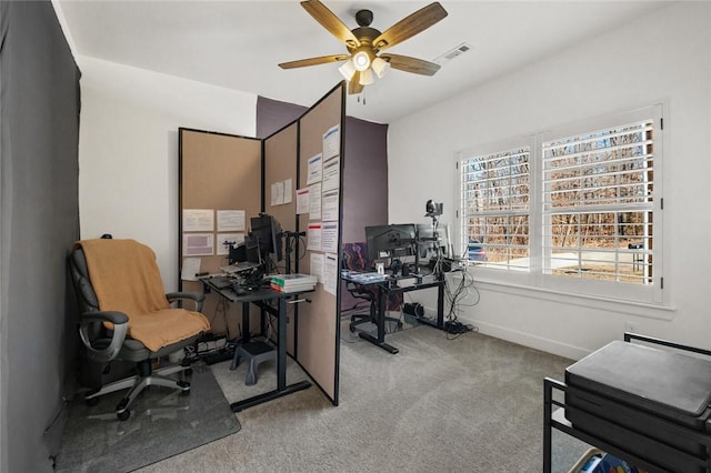 carpeted home office featuring ceiling fan