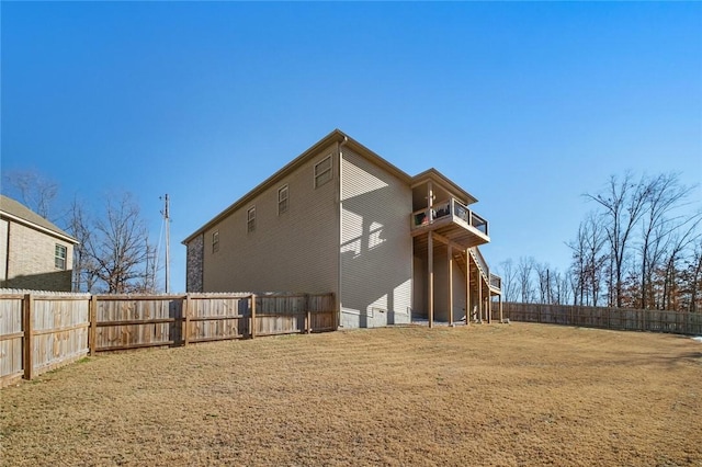 rear view of property with a balcony and a lawn