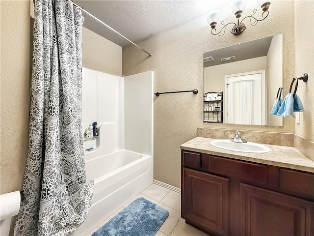 bathroom with a textured ceiling, tile patterned floors, vanity, and shower / bath combo