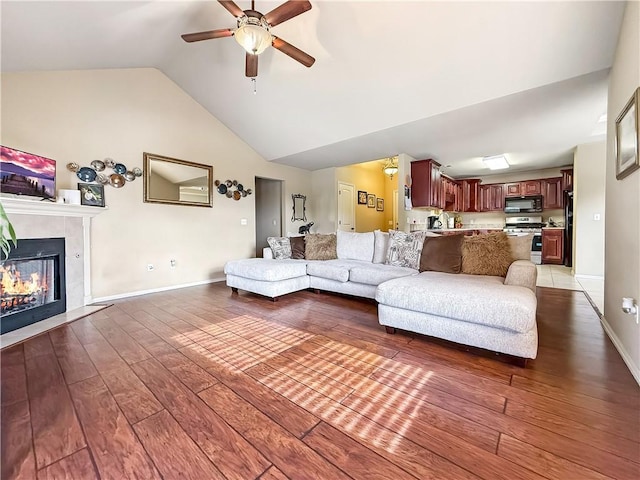 living room featuring vaulted ceiling, ceiling fan, and wood-type flooring