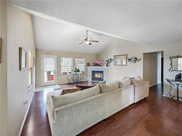 living room featuring a textured ceiling, ceiling fan, and dark hardwood / wood-style flooring