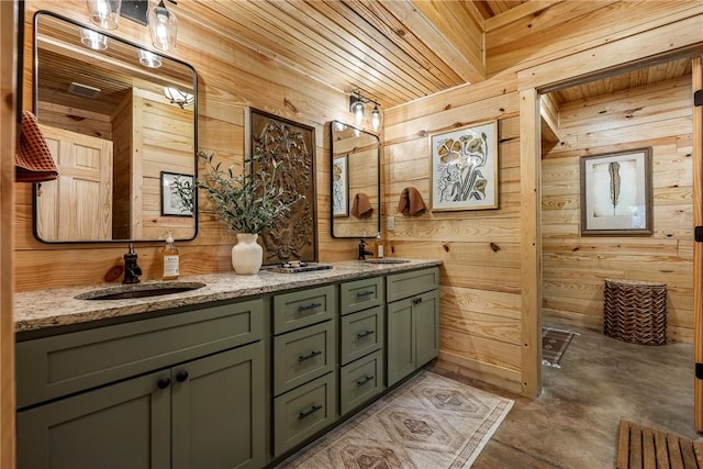 bathroom featuring wooden walls, double vanity, wooden ceiling, and a sink