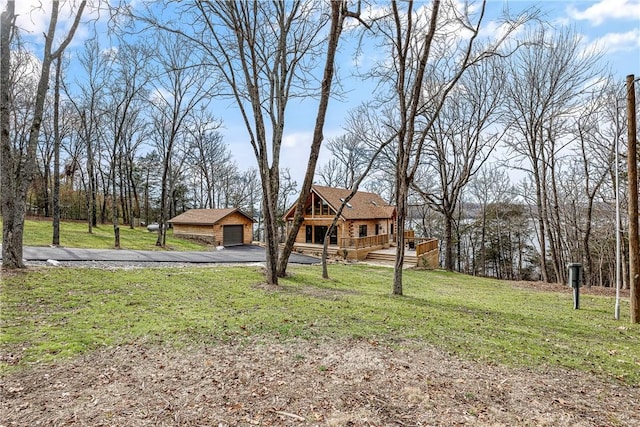 view of front of property with a wooden deck, a garage, and a front lawn