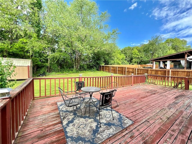 wooden deck with a lawn and a storage shed