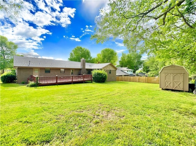 view of yard with a wooden deck and a storage shed