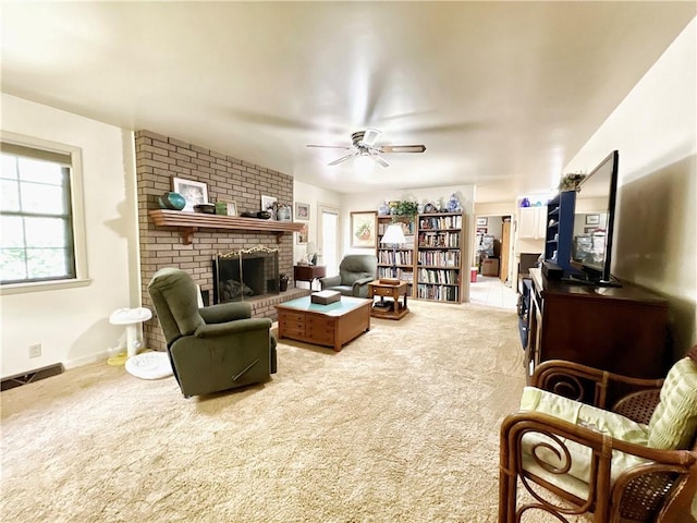 carpeted living room with ceiling fan and a fireplace