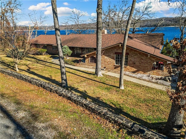 single story home with a front yard and a water view