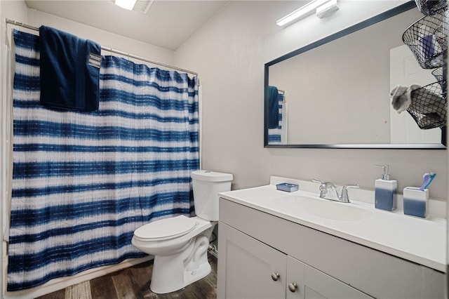 bathroom featuring hardwood / wood-style flooring, toilet, vanity, and walk in shower