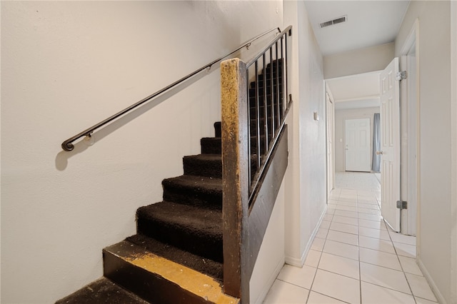 stairway with tile patterned floors