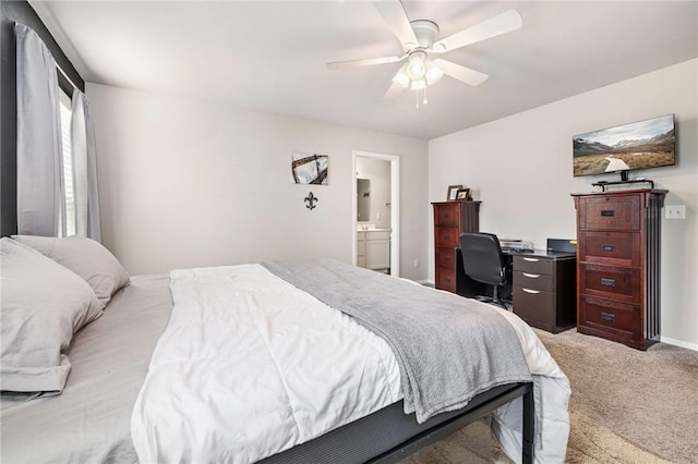 bedroom featuring light carpet, connected bathroom, baseboards, and a ceiling fan