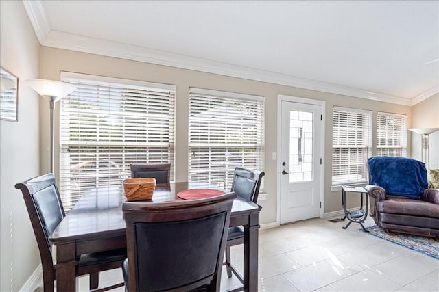 tiled dining area featuring a healthy amount of sunlight and ornamental molding