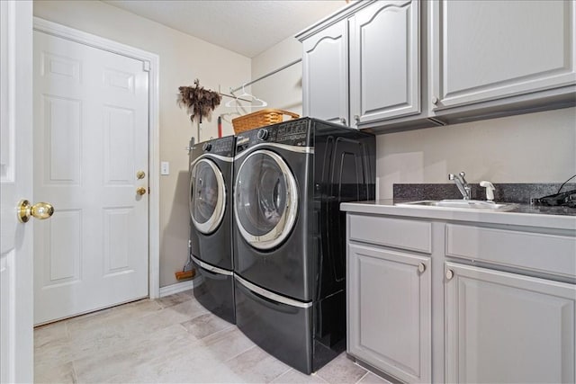 washroom featuring independent washer and dryer, sink, a textured ceiling, light tile patterned floors, and cabinets