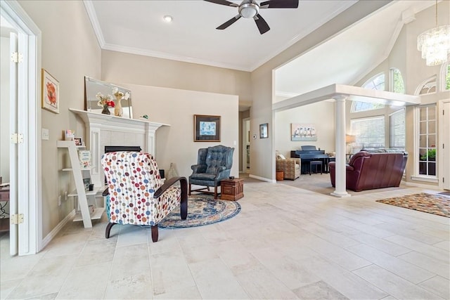 sitting room featuring built in features, ornamental molding, ceiling fan with notable chandelier, and a tile fireplace