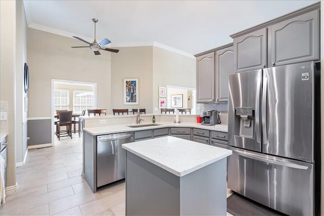 kitchen with gray cabinets, a center island, kitchen peninsula, sink, and stainless steel appliances