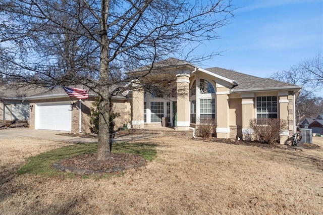 view of front of home with roof with shingles, stucco siding, an attached garage, a front yard, and driveway