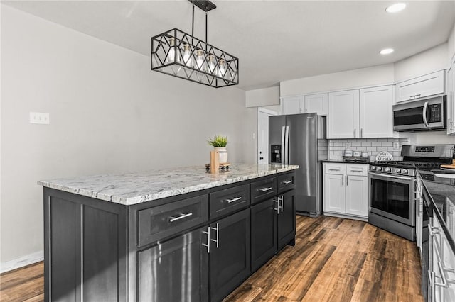 kitchen with dark hardwood / wood-style floors, a center island, white cabinetry, hanging light fixtures, and appliances with stainless steel finishes