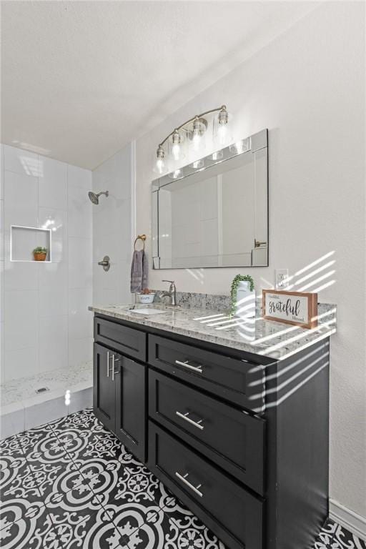 bathroom featuring vanity, tile patterned floors, and tiled shower