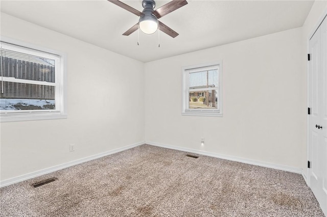 empty room with ceiling fan and carpet flooring