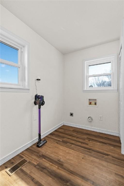 washroom featuring a wealth of natural light, dark wood-type flooring, washer hookup, and hookup for an electric dryer