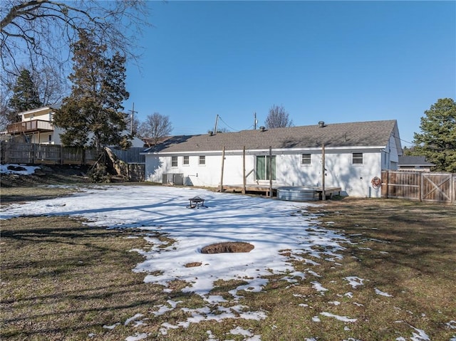 snow covered back of property featuring an outdoor fire pit