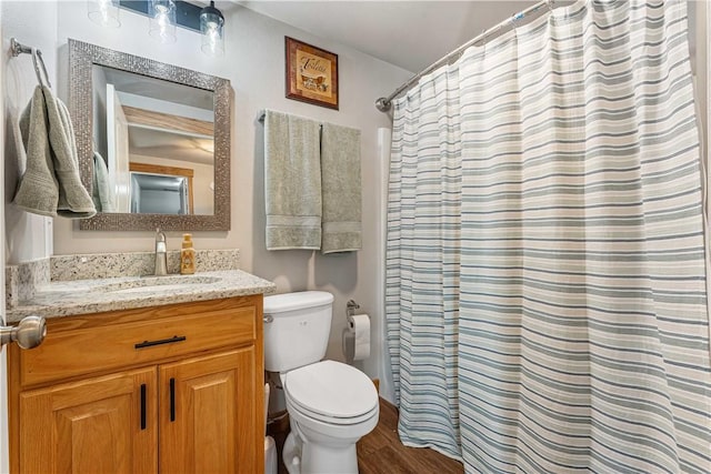 bathroom with toilet, vanity, a shower with curtain, and hardwood / wood-style flooring