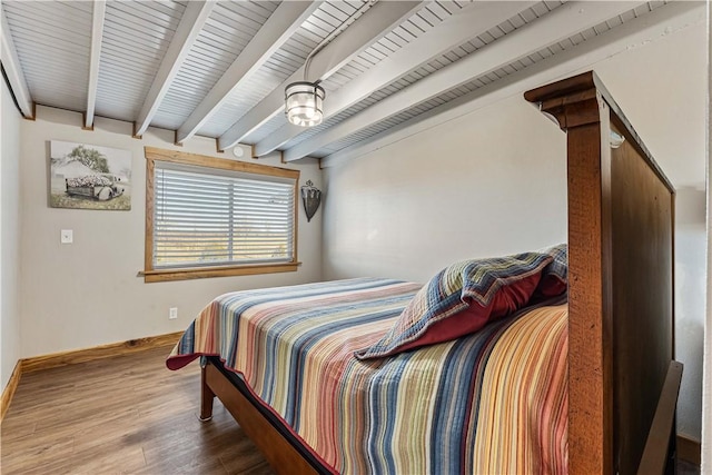 bedroom with beam ceiling and wood-type flooring