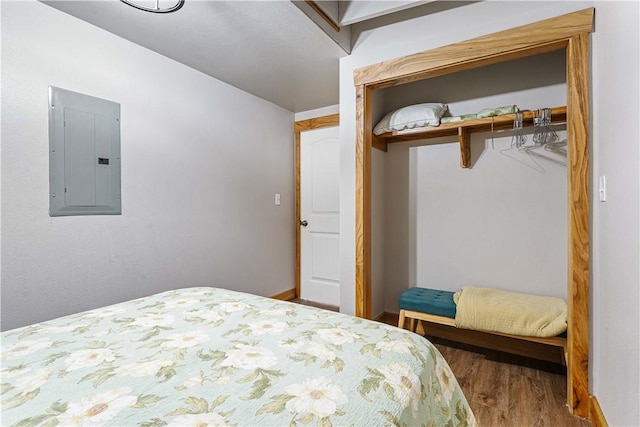 bedroom featuring electric panel and hardwood / wood-style floors