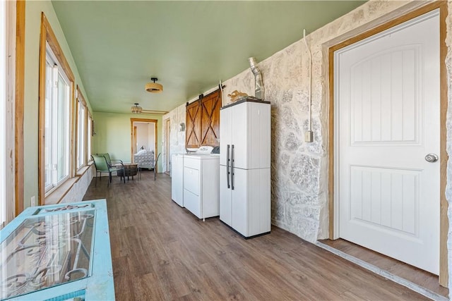 interior space featuring separate washer and dryer, white refrigerator, a barn door, and hardwood / wood-style floors