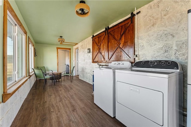 clothes washing area featuring separate washer and dryer, dark hardwood / wood-style floors, and a barn door