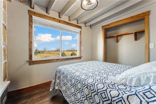 bedroom featuring a closet, dark hardwood / wood-style flooring, beam ceiling, and wooden ceiling