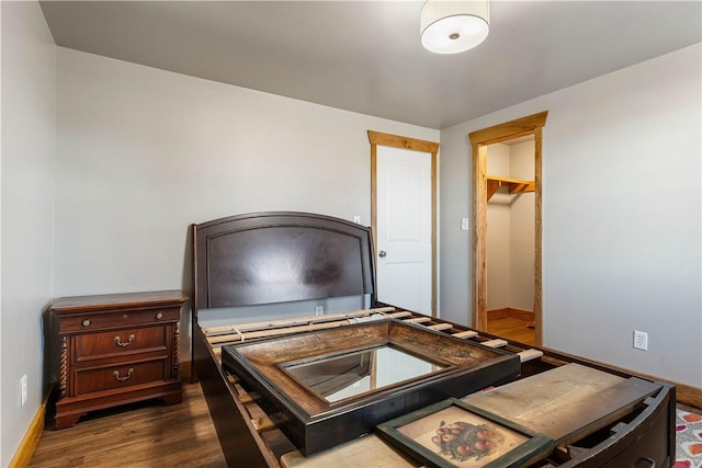 bedroom featuring dark hardwood / wood-style floors, a closet, and a walk in closet