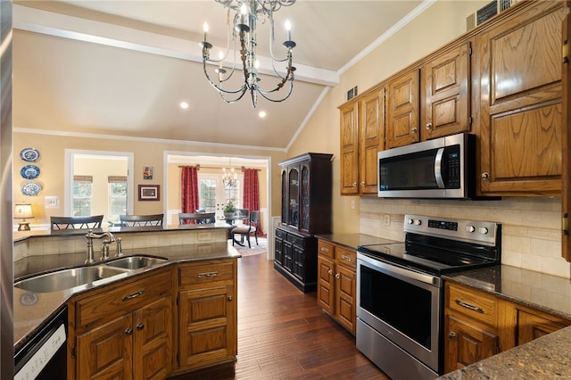 kitchen with appliances with stainless steel finishes, dark hardwood / wood-style floors, lofted ceiling with beams, backsplash, and a notable chandelier