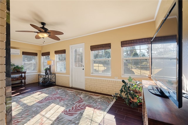 unfurnished sunroom with a wall unit AC and ceiling fan