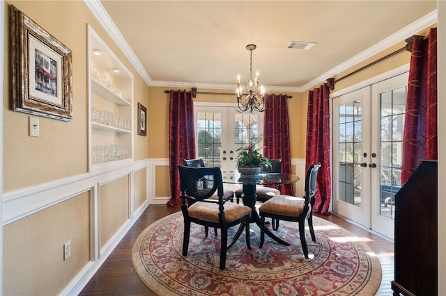 dining area with french doors, a chandelier, ornamental molding, dark hardwood / wood-style flooring, and built in features