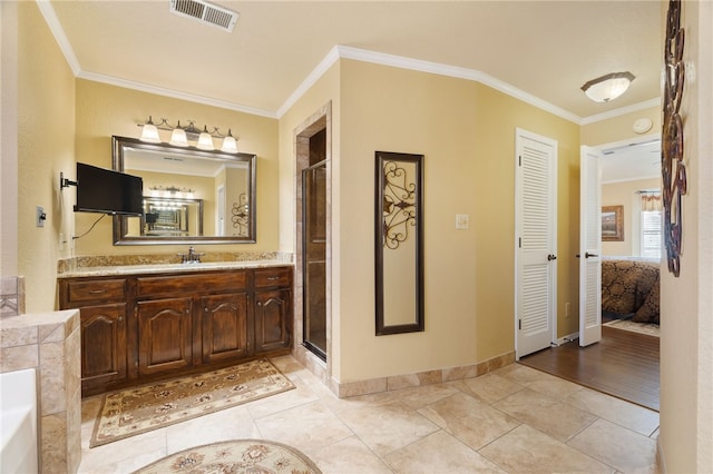 bathroom with crown molding, vanity, a shower with shower door, and tile patterned flooring