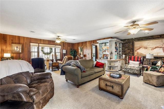 living room featuring ceiling fan, light colored carpet, and a textured ceiling