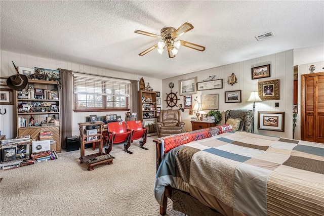 bedroom featuring a textured ceiling, carpet floors, and ceiling fan