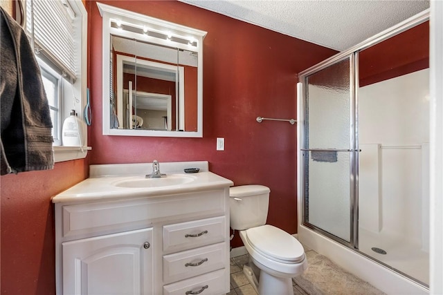 bathroom featuring tile patterned flooring, vanity, a textured ceiling, toilet, and walk in shower