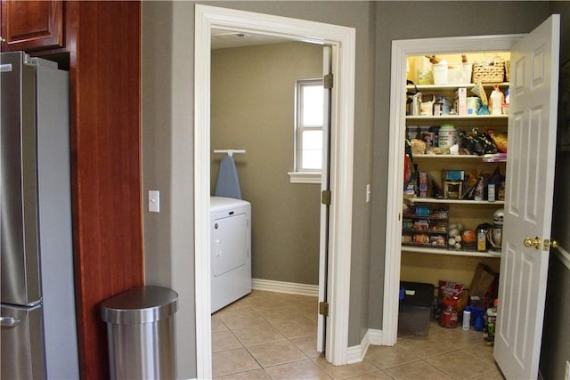 clothes washing area featuring washer / clothes dryer and light tile patterned floors