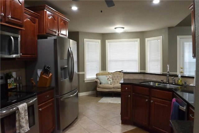 kitchen with stainless steel appliances, light tile patterned flooring, and sink