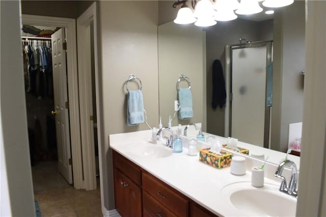 bathroom with an enclosed shower, vanity, and tile patterned flooring