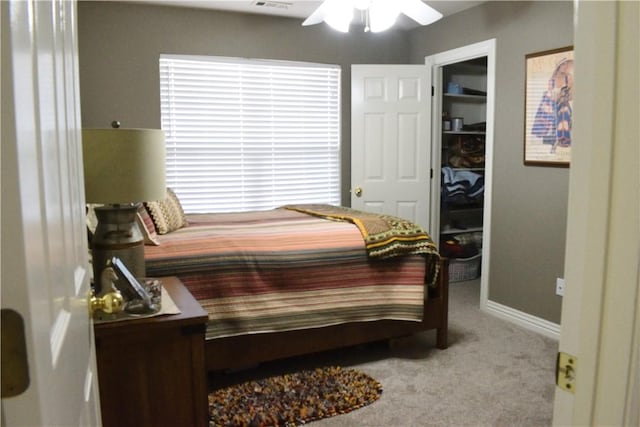 bedroom with ceiling fan, light colored carpet, a spacious closet, and a closet