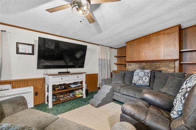 carpeted living room featuring wooden walls, a textured ceiling, and ornamental molding