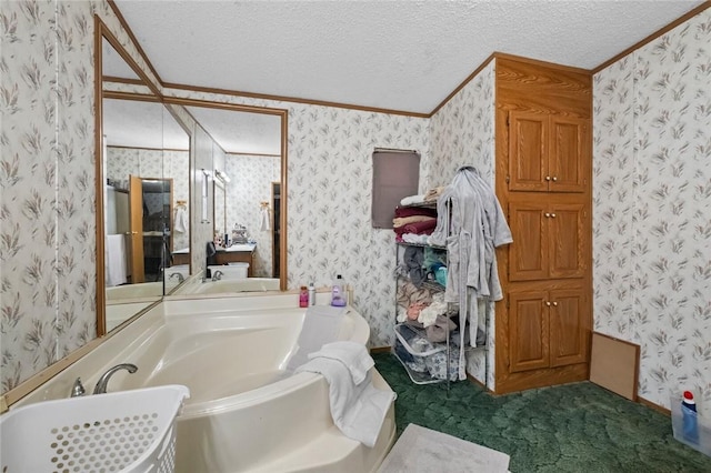 bathroom with a textured ceiling, a bathtub, and ornamental molding