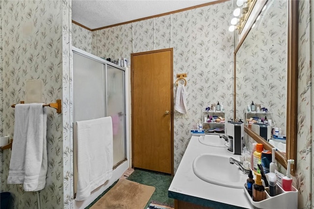 bathroom featuring a textured ceiling, ornamental molding, walk in shower, and vanity